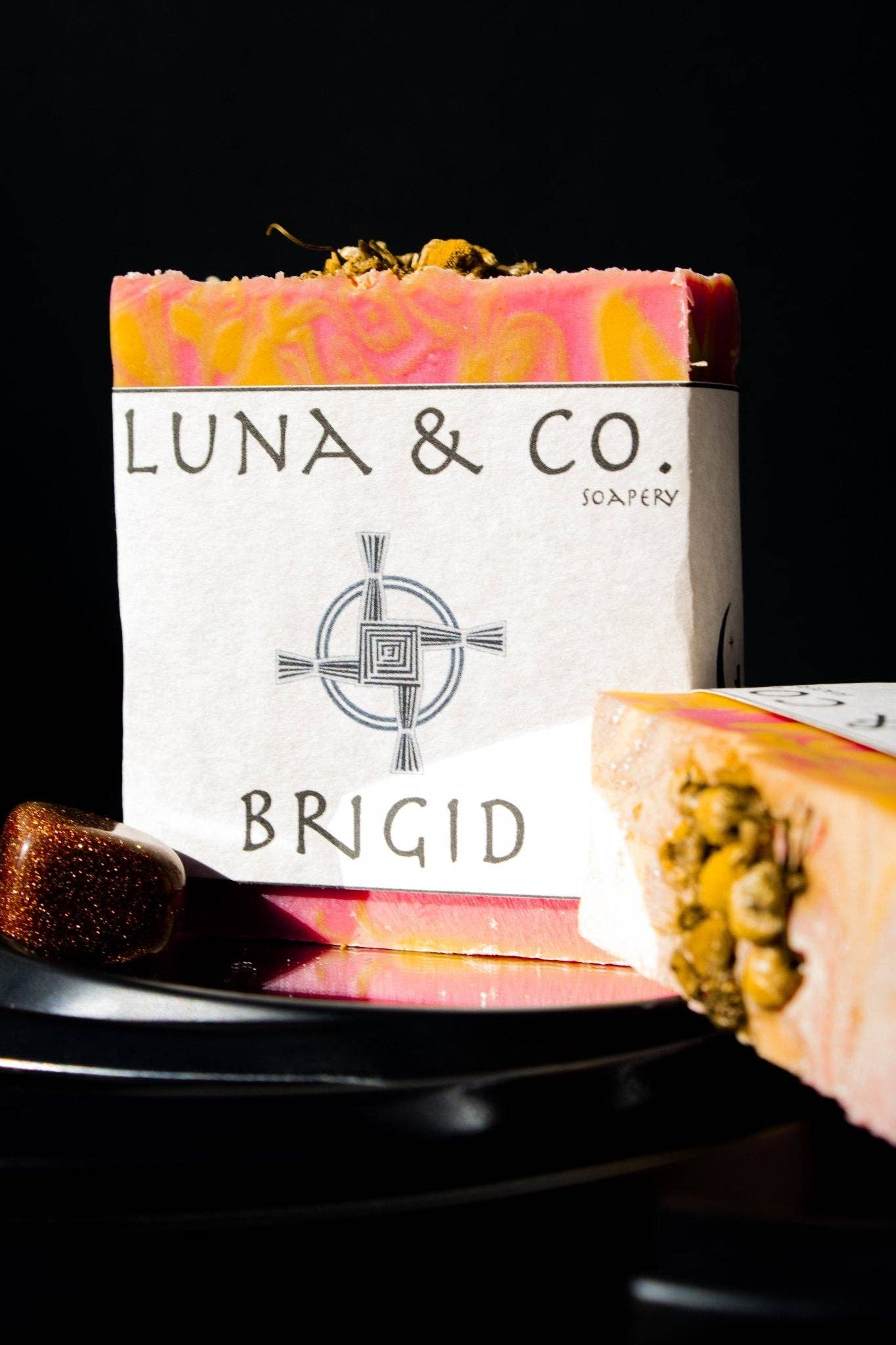 Luna & Co. soap bar with decorative elements on a black background