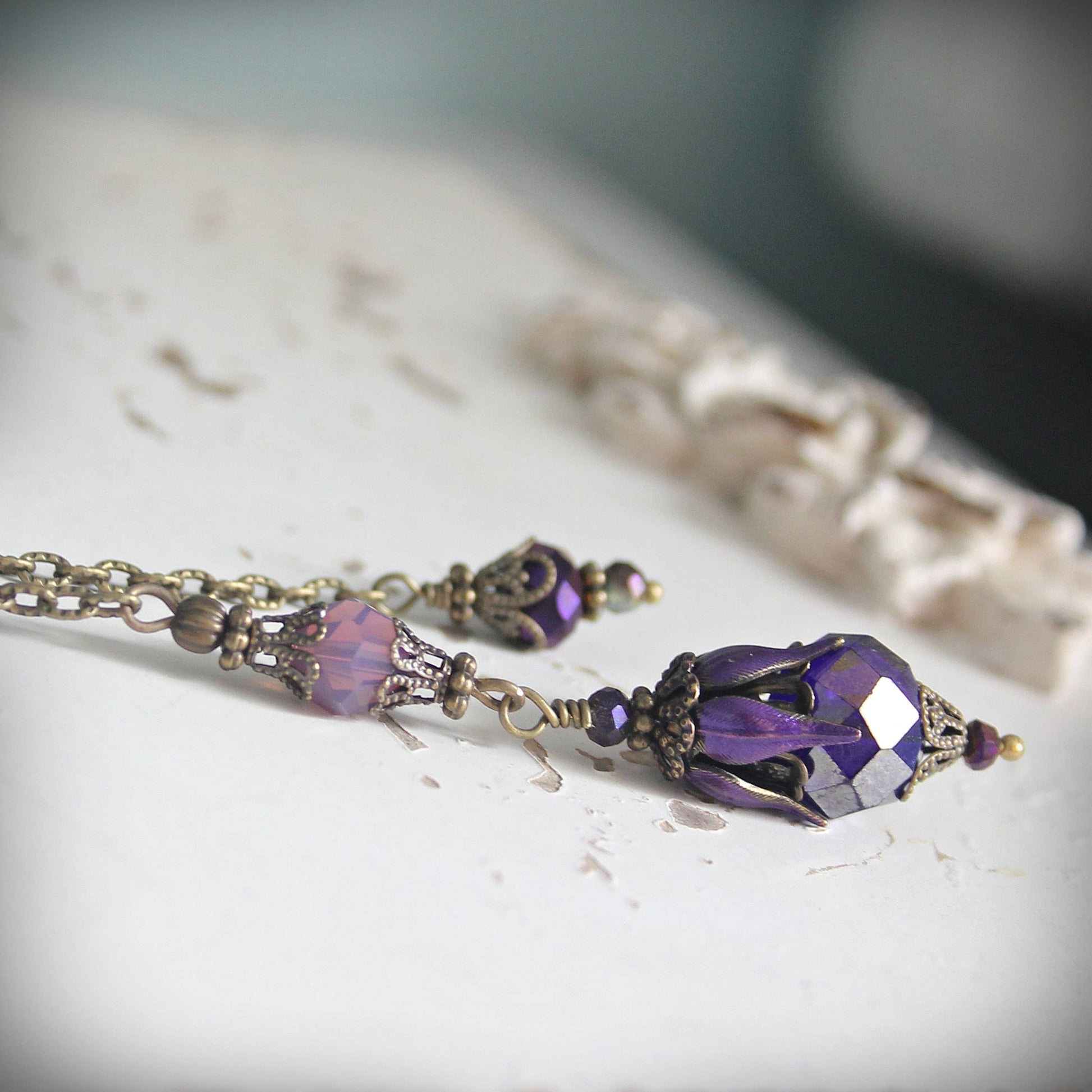 Purple beaded pendulum with gold accents on a light surface
