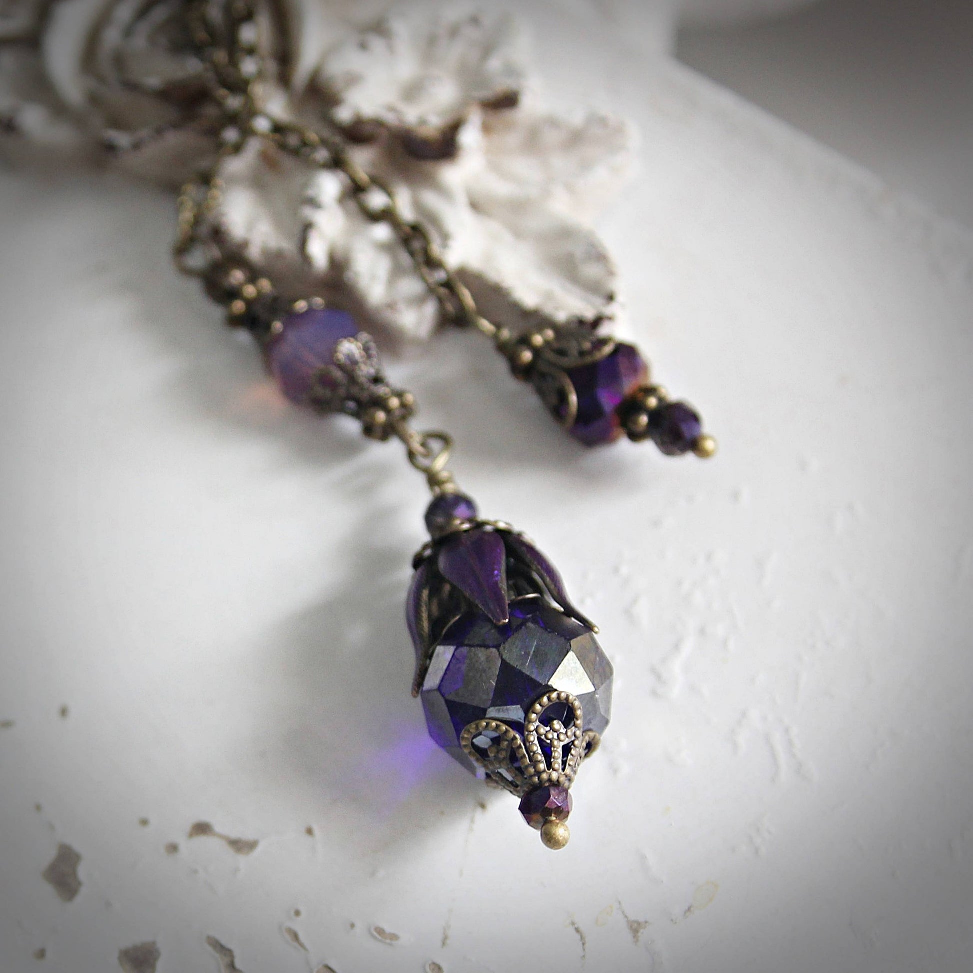 Purple beaded pendulum on a textured white surface