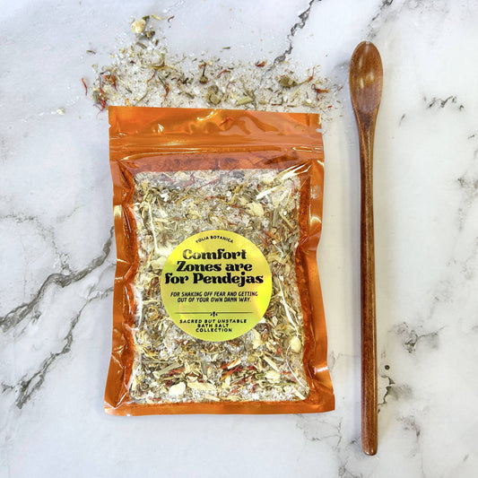 Packaged herbal mix with a wooden spoon on a marble surface