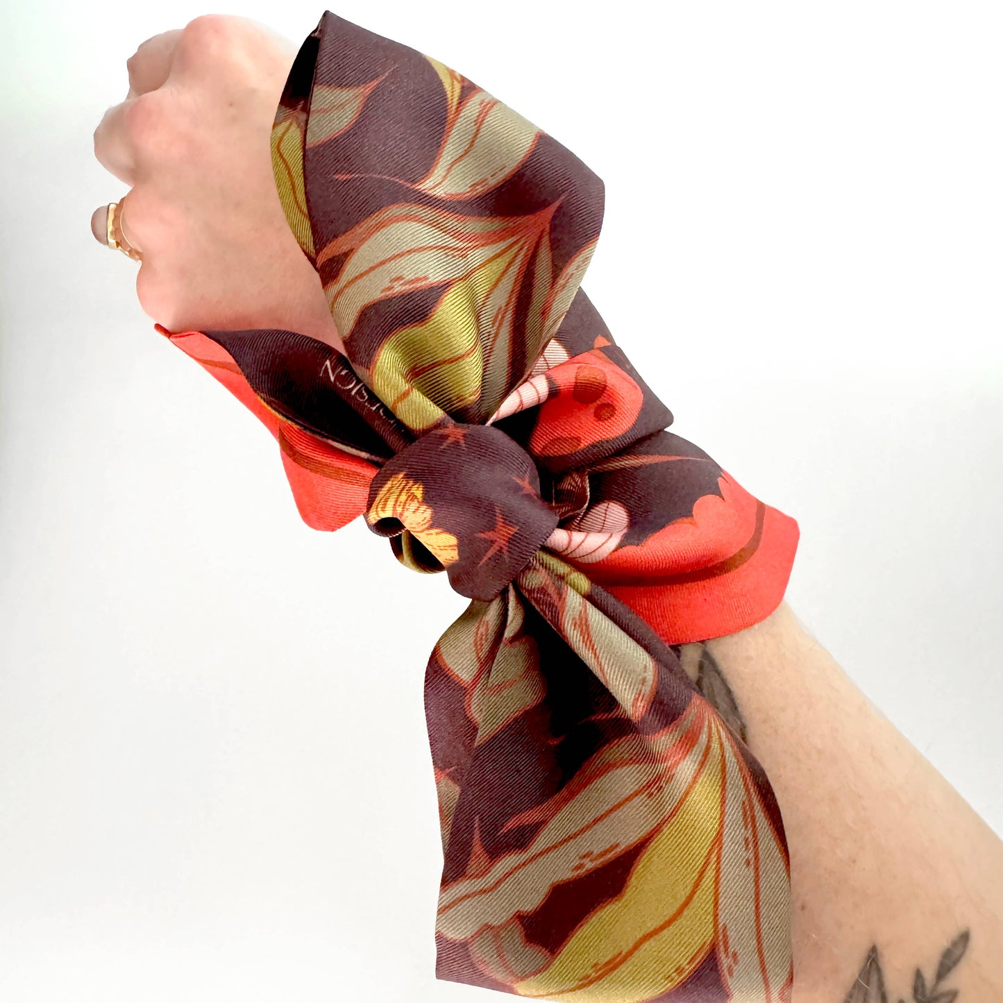 Colorful scarf wrapped around a wrist with a white background