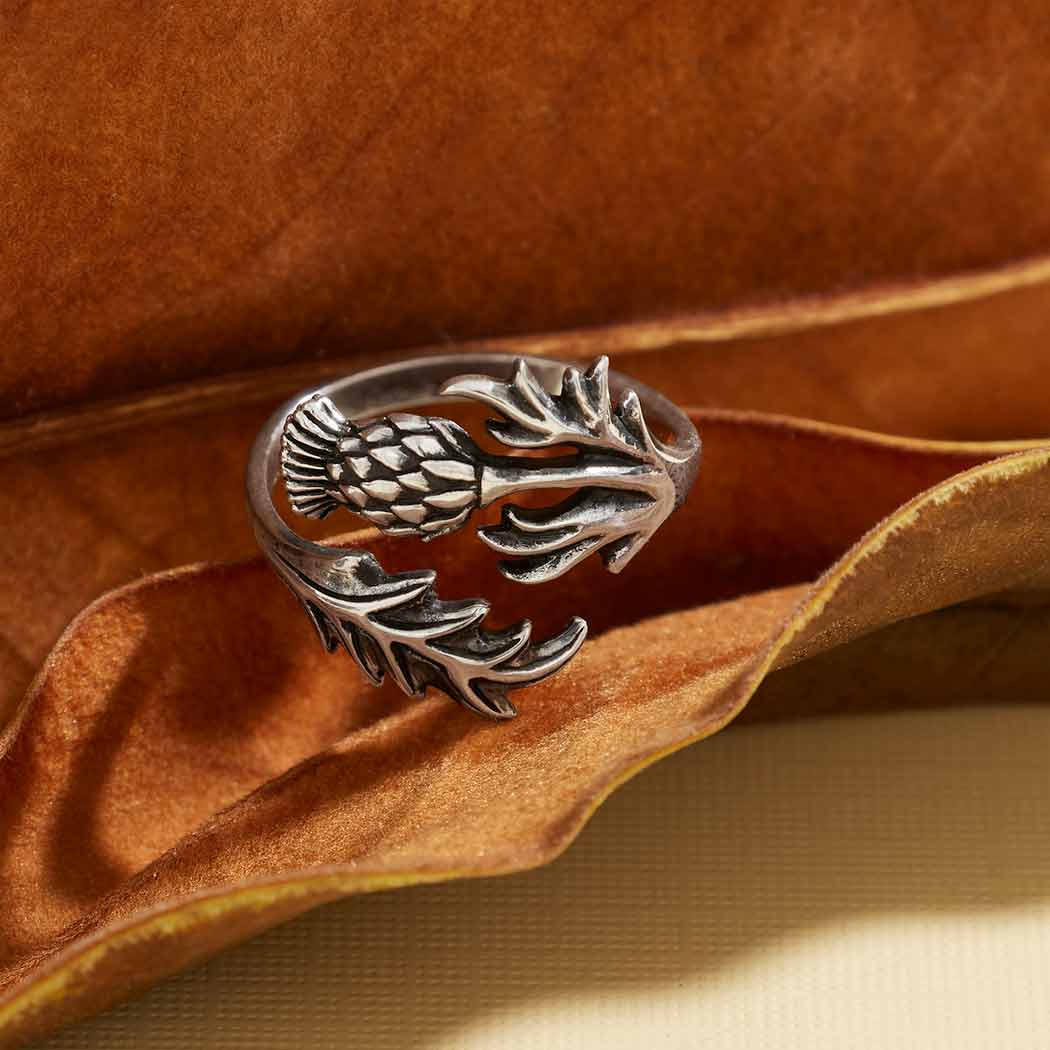 Silver ring with leaf design on a brown leaf