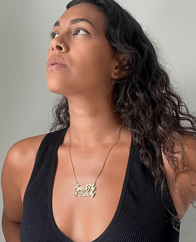 Model wearing a gold necklace that says "Smash the Patriarchy".