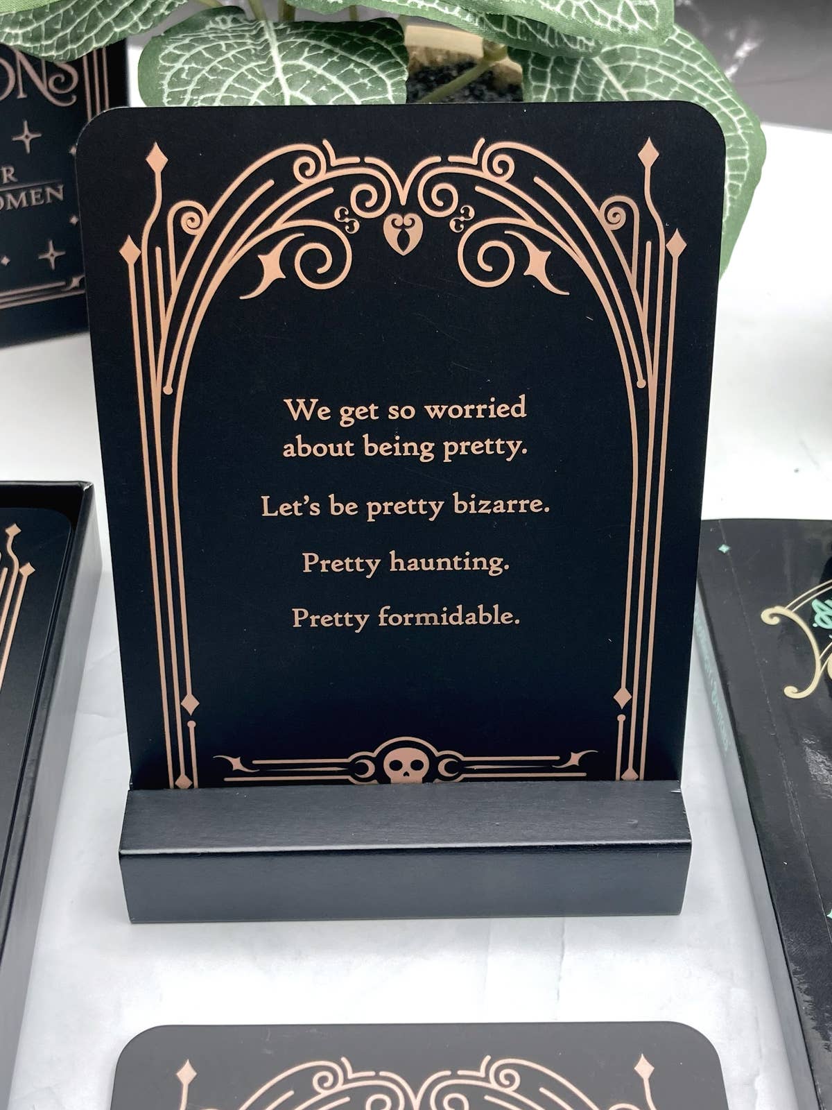 Decorative card with a quote on a stand, surrounded by other cards.