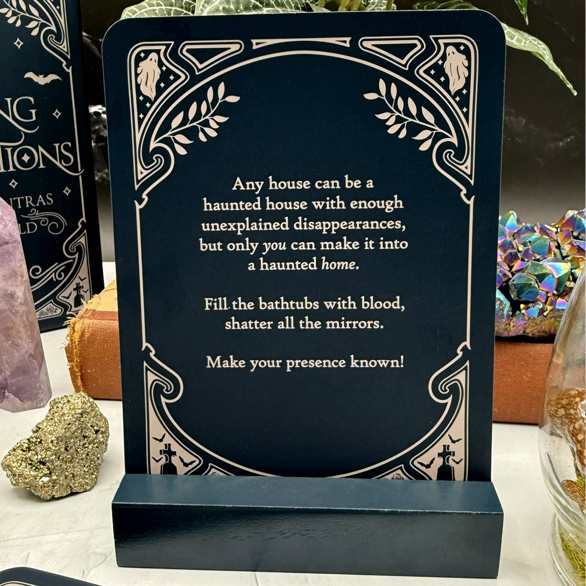 Decorative sign with Halloween-themed text on a stand, surrounded by decorative items.