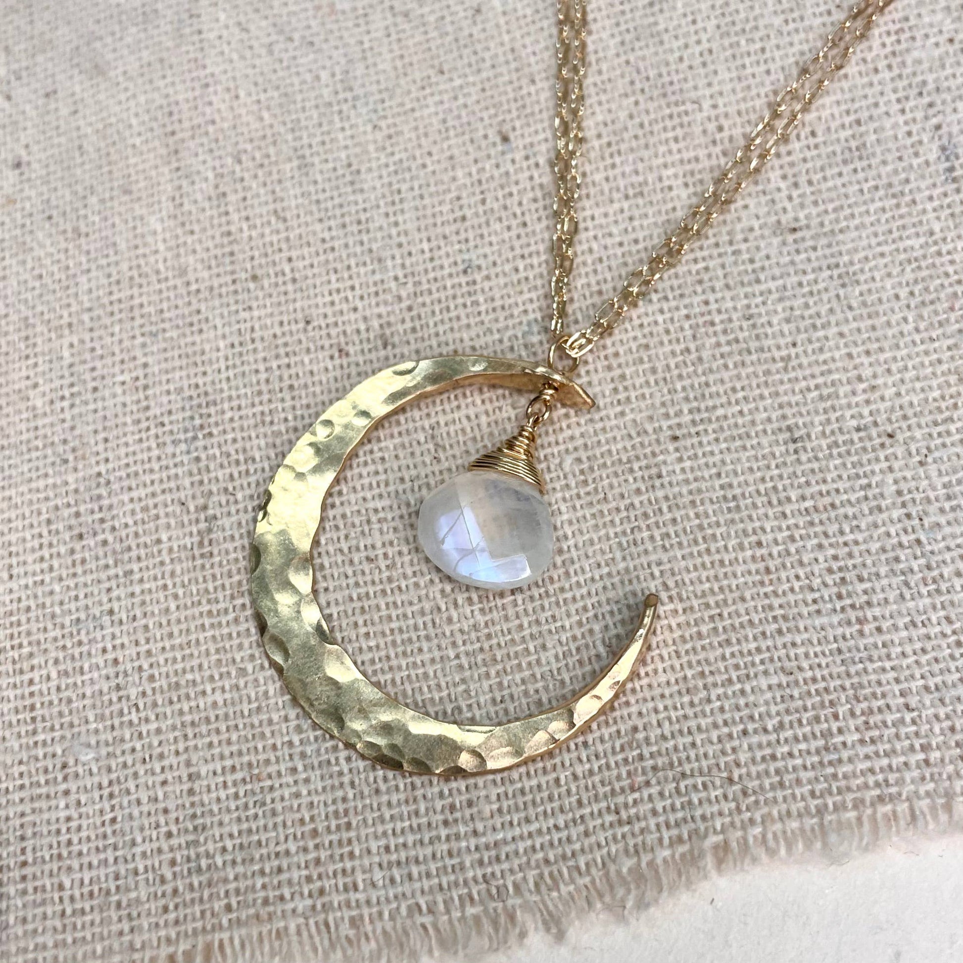 Sterling silver and moonstone crescent moon necklace on a light background.