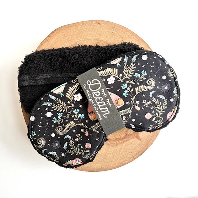 Sleep mask on a wood slab with a white background.