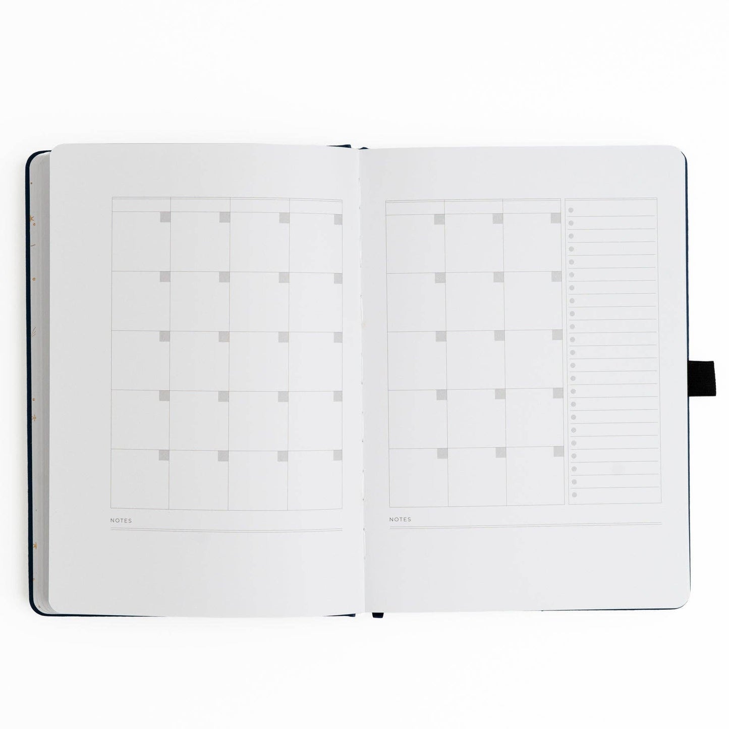 Open planner with grid and dot grid pages on a white background