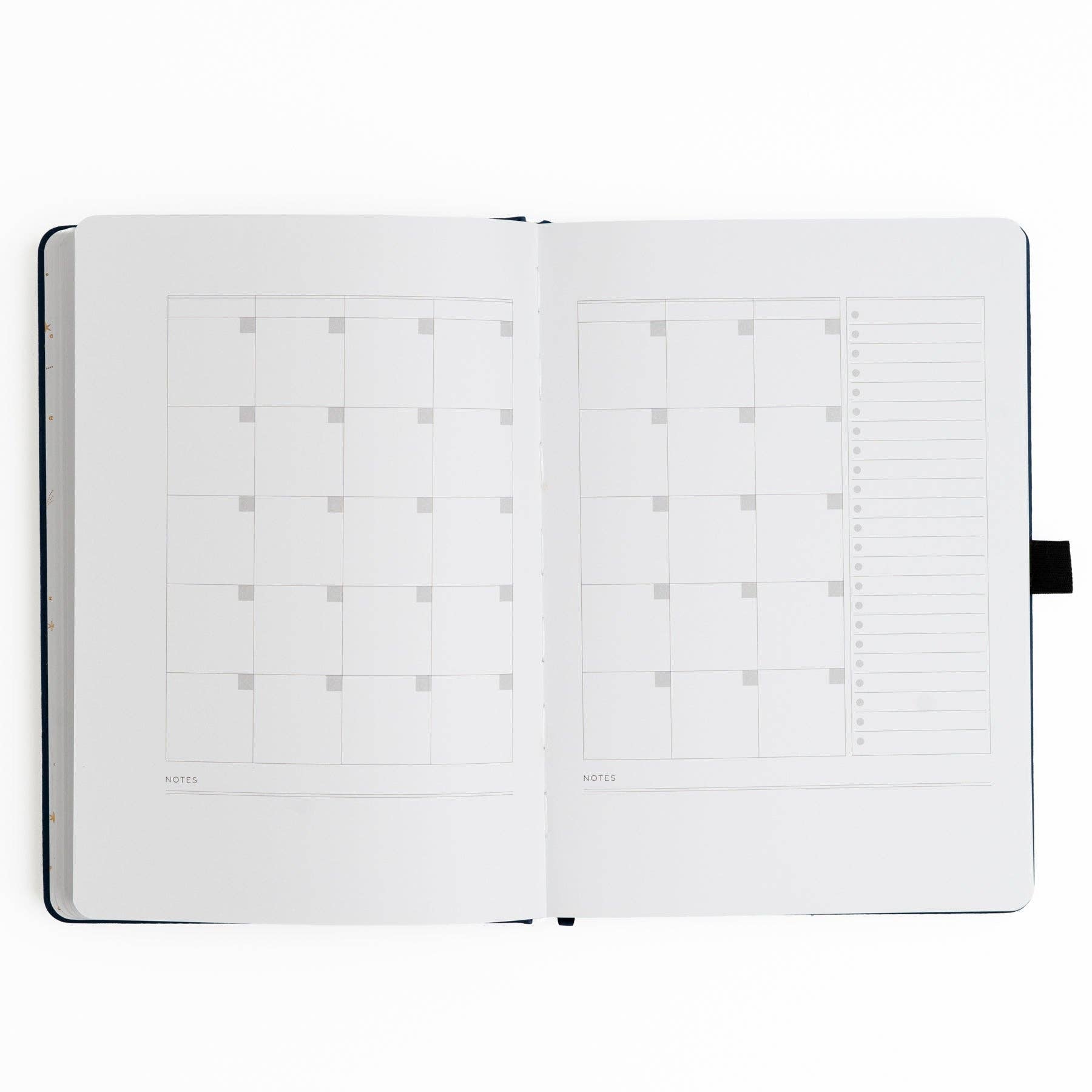 Open planner with grid and dot grid pages on a white background
