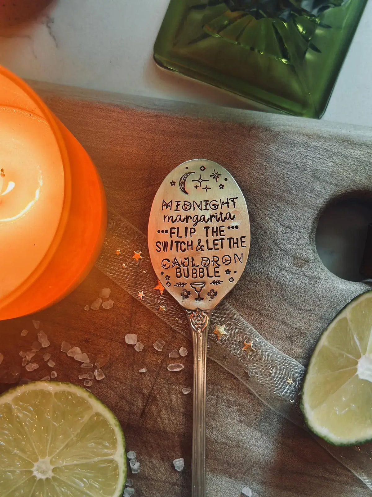 A decorative metal spoon with hand-stamped text reading 'Midnight margarita.
