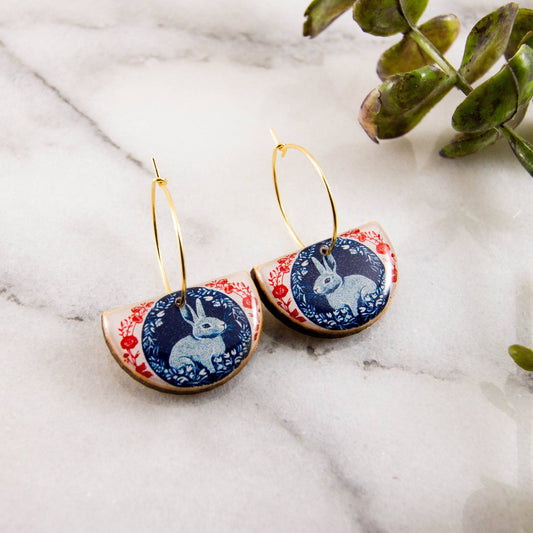 Pair of earrings with rabbit design on a marble surface
