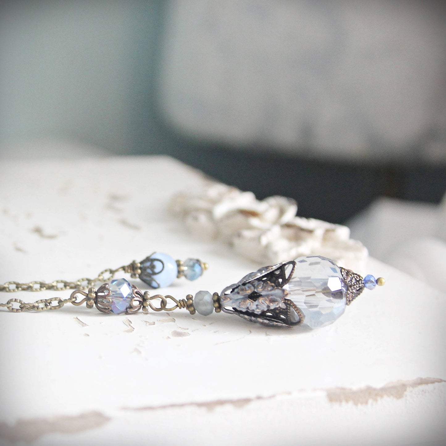 Necklace with a large crystal pendant on a textured surface
