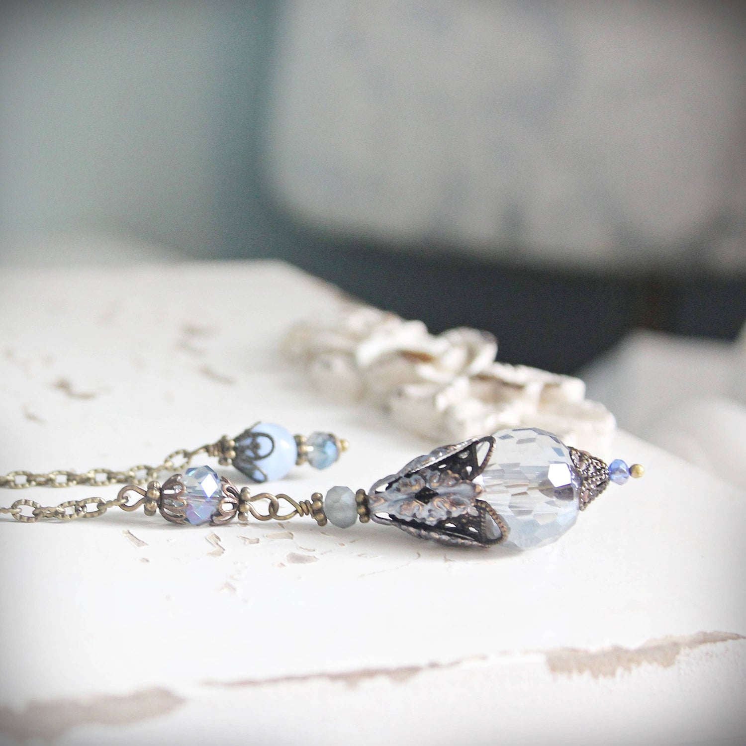 Necklace with a large crystal pendant on a textured surface
