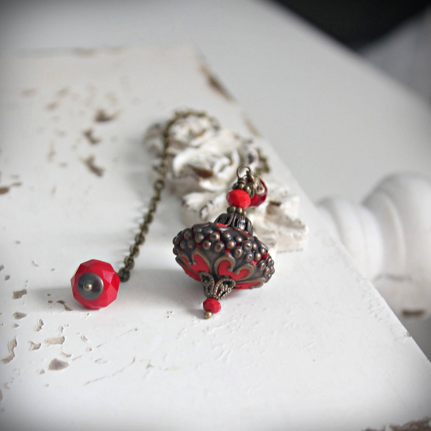 Necklace with red and black beads on a textured white surface