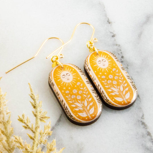 Decorative earrings with floral patterns on a marble surface