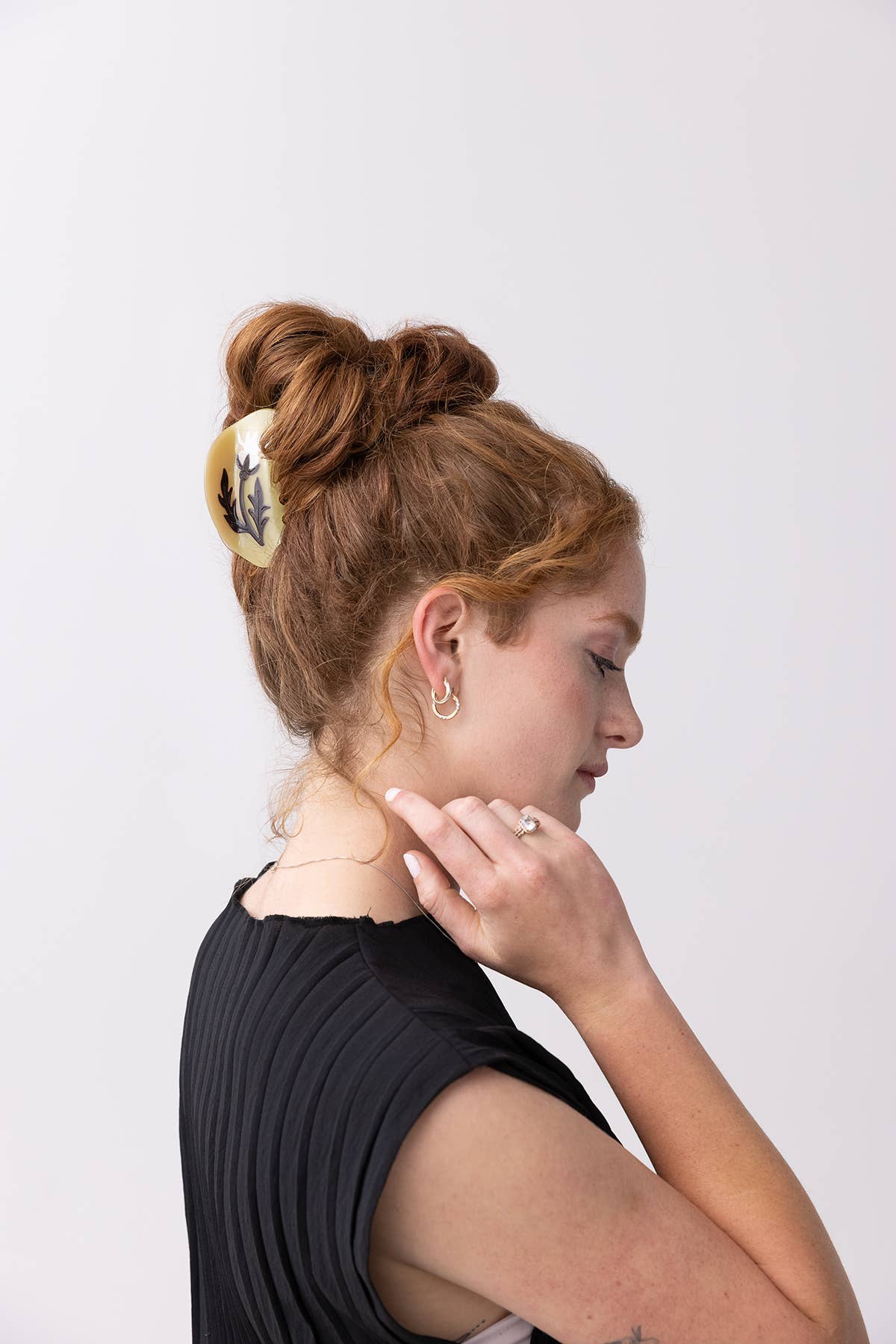 Woman with styled hair and black top against a white background