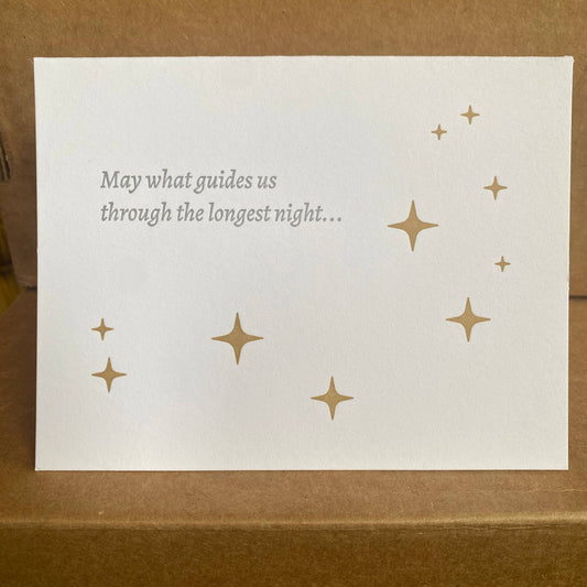White card with gold stars and text on a brown background